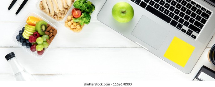 Clean Healthy Ready Ot Eat Low Fat Food In Meal Box Set Prepared For Lunch On Working Table With Laptop Computer, Overhead View