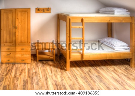 Clean hostel room with wooden bunk beds.
