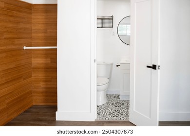 A clean interior shot taken from the master bedroom, looking into the adjoining bathroom of a.  The bathroom, visible from the bedroom, showcases a contemporary black and white color scheme. - Powered by Shutterstock