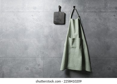 Clean kitchen apron with pattern and board on grey tiled wall. Space for text