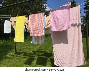 Clean Laundry Clothes Towels Drying Outdoor In Washing Line By Sunshine Solar Energy, Forest Landscape Background, Summer Day, Ecological Way To Do Housework, Clothespin On Rope, Shadow In Green Grass