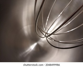 Clean metal whisk and aluminum bowl of kitchen mixer close-up. cooking tools