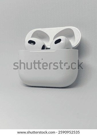A clean and minimalist aesthetic shot of a pair of wireless headphone in their charging case.