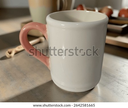 A clean and minimalistic side view of the ceramic mug is shown here. The focus is on the mug's smooth texture, simple shape, and the contrast between its white body and pink handle.
