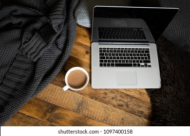 Clean, Modern Laptop On Dark Rustic Wood With Cushions, Blanket, Mug Of Coffee And Sheepskin Rug. Brown, Black, White. Semi Flat Lay/overhead Shot. 