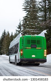 Clean Natural Gas Bus Driving Away On A Snowy Mountain Road