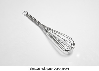 Clean New Steel Whisk Isolated On White Background. Cooking Egg Beater Mixer Whisker With Plastic Handle.High Resolution Photo. Mock Up