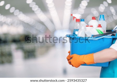 Clean and orderly. A cleaning process where a worker wearing protective gloves holds a bucket of cleaning products.