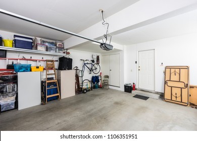 Clean organized suburban residential two car garage with tools, file cabinets and sports equipment.  