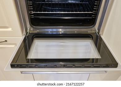 A Clean Oven With Washed Glass Built Into The Furniture In The Home Kitchen