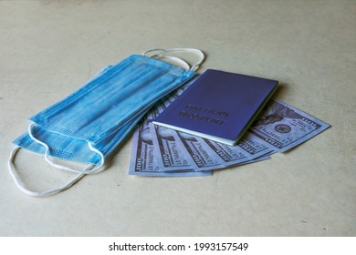 A Clean Passport Crust On A Background Of US Dollars And A Medical Mask. Passport In English And Russian.