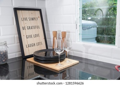 Clean Plates And Wine Glass On Kitchen Counter By The Window.