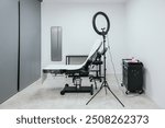 Clean and professional microblading studio setup with a work chair and lighting equipment