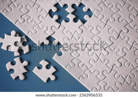 Clean puzzle elements on the background. Empty puzzle piece on table. Teamwork concept.
