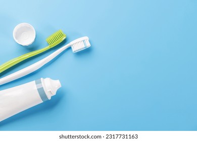 A clean and refreshing image featuring toothpaste and toothbrushes, promoting oral hygiene and a bright smile. Flat lay with copy space