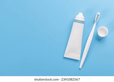 A clean and refreshing image featuring toothpaste and toothbrush, promoting oral hygiene and a bright smile. Flat lay with copy space