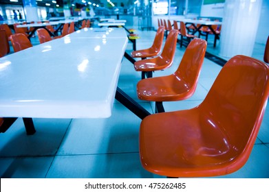 Clean School Cafeteria With Many Empty Seats And Tables.