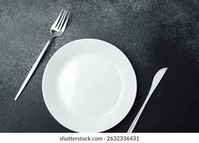 A clean, simple table display features an empty plate and utensils awaiting food.