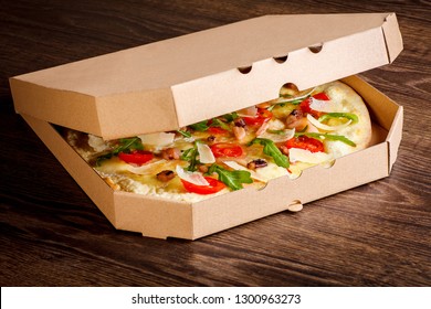 Clean Top Surface Open Pizza Box With Tasty Colorful Pizza Inside For Your Brand. On A Brown Wooden Table