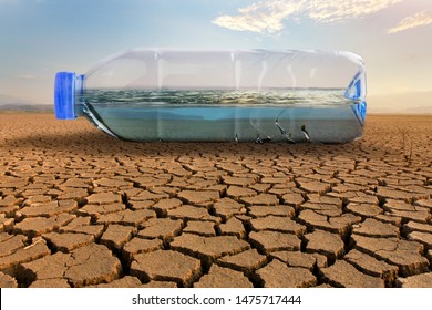 Clean water in plastic bottle on dry land of crakced earth metaphor save water, water crisis and Climate change impact to demand of water
