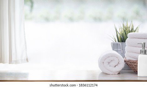 Clean white bath towels  on wooden counter table, copy space.