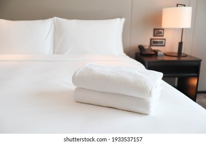 Clean White Bath Towels On The Neatly Clean Bed Of Hotel Room - Coziness And Clean Concept	