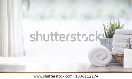 Clean white bath towels  on wooden counter table, copy space.