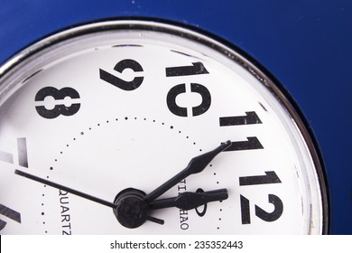 Clean white clock showing five seconds to midnight