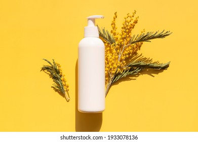 Clean White Cosmetic Containers Bottles With Mimosa Flowers On Yellow Background Flat Lay Top View. Blank Label Package For Branding Mock-up. Spring Cosmetics Concept. Natural Organic Beauty Product