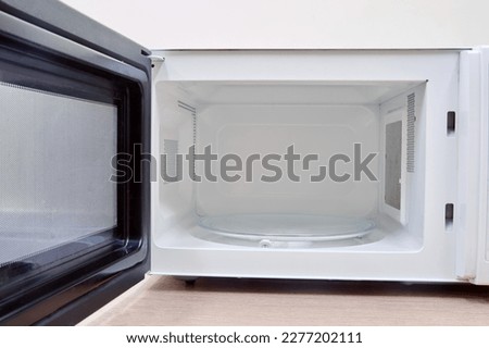 Clean white microwave oven with open door after washing and cleaning