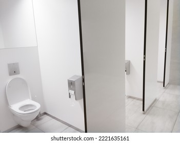 Clean white Public Washroom WC stall with white plastic toilet bowl seat inside with open lid - Shutterstock ID 2221635161