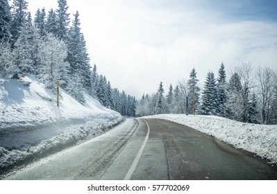 Clean winter road on mountain with turns and curve with trees under the snow. Winter road with yellow marking double line and singns at winter season. - Powered by Shutterstock