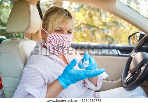 Cleaner with face mask uses\
disinfectants in rental cars because of coronavirus\
pandemic