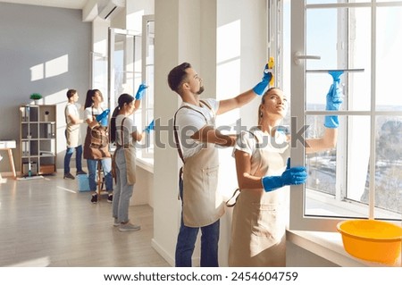 Cleaner group window washing with squeegee, working, professional janitor service busy completing cleaning tasks at home, office. People employed to take care of room, company maintaining washing 