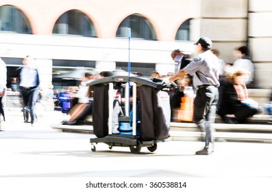 Cleaner man going throughout the St. Paul's cathedral square with rubbish bin on the wheel. City of London - Powered by Shutterstock