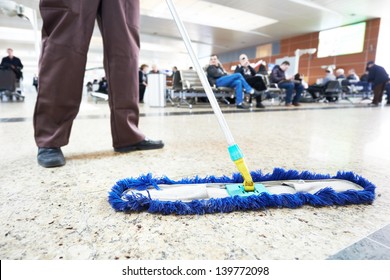 Cleaner With Mop And Uniform Cleaning Hall Floor Of Public Business Building