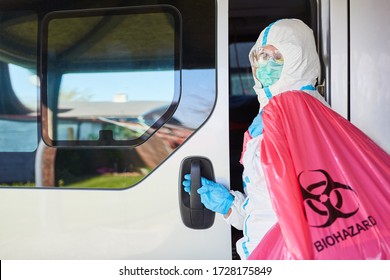 Cleaner In Protective Clothing Transports Biohazard Hazardous Waste From Clinic With Transporter For Waste Disposal