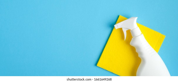 Cleaner Spray Bottle And Yellow Rag On Blue Background. Cleaning Service Banner Mockup. Housecleaning And Housekeeping Concept. Flat Lay, Top View