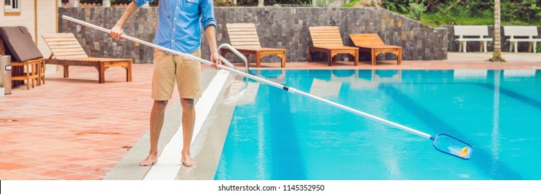 Cleaner of the swimming pool . Man in a blue shirt with cleaning equipment for swimming pools, sunny BANNER, long format