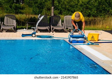 The Cleaner Turns On An Automatic Cleaning Robot To Clean The Pool. Automatic Pool Cleaning. Concept Photo  Pool Cleaning, Hotel Staff, Service.