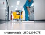 Cleaner using mops, cleaner with mop and uniform cleaning hall floor, hospital cleaning floor with mop in patient room the hospital epoxy floor