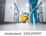 Cleaner using mops, cleaner with mop and uniform cleaning hall floor, hospital cleaning floor with mop in patient room the hospital epoxy floor