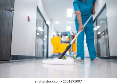 Cleaner using mops, cleaner with mop and uniform cleaning hall floor, hospital cleaning floor with mop in patient room the hospital epoxy floor