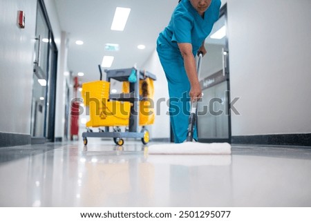 Cleaner using mops, cleaner with mop and uniform cleaning hall floor, hospital cleaning floor with mop in patient room the hospital epoxy floor