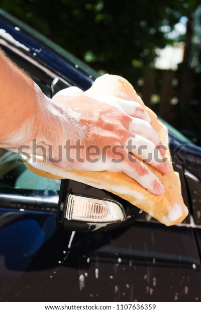 cleaning automobile with sponge at car wash.Car\
washing concept