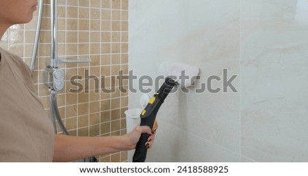 Cleaning bathroom tiles with steam. Disinfecting the bathroom with steam. 