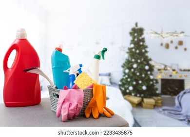 Cleaning before Christmas. Multicolored cleaning supplies. Sponges, rags and spray with festive decorations against modern home background. - Powered by Shutterstock