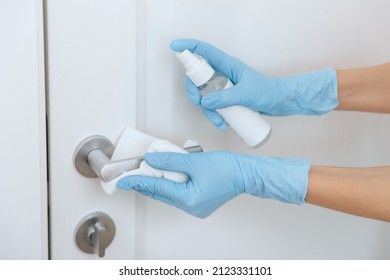 Cleaning Black Door Handle With An Antiseptic Wet Wipe, Blue Gloves And Sanitizer. Woman Hand Using Towel For Cleaning. Sanitize Surfaces Prevention In Hospital And Public Spaces Against Corona Virus.