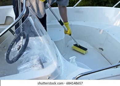 Cleaning boat with brush by hands