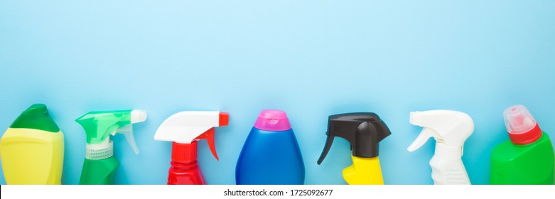 Cleaning Bottles For Different Surfaces In Kitchen, Bathroom And Other Rooms. Spring Regular Cleanup. Light Pastel Blue Background. Closeup. Top View.  Wide Banner. Empty Place For Text Or Logo.